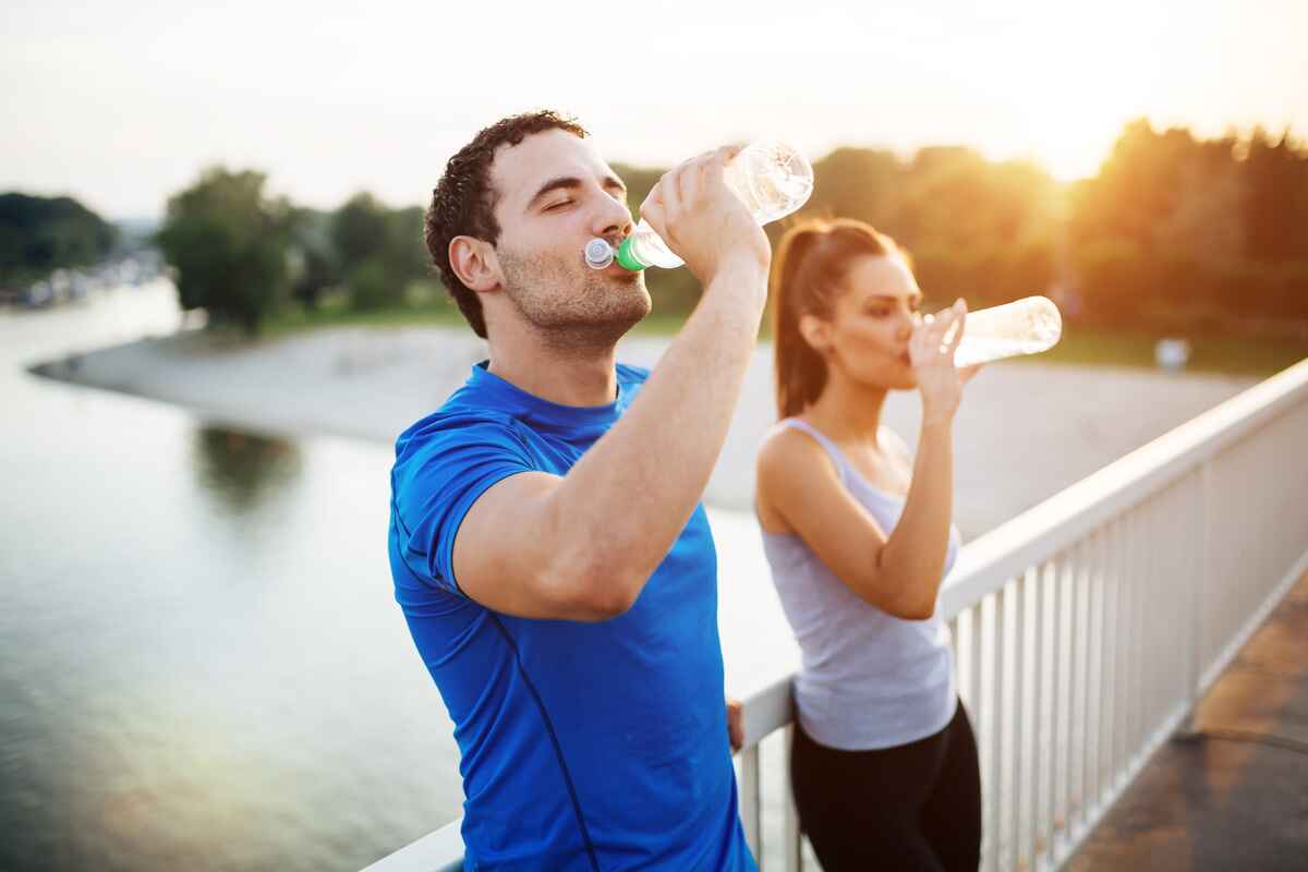 Couple drinks water to avoid heat illness on a hot day